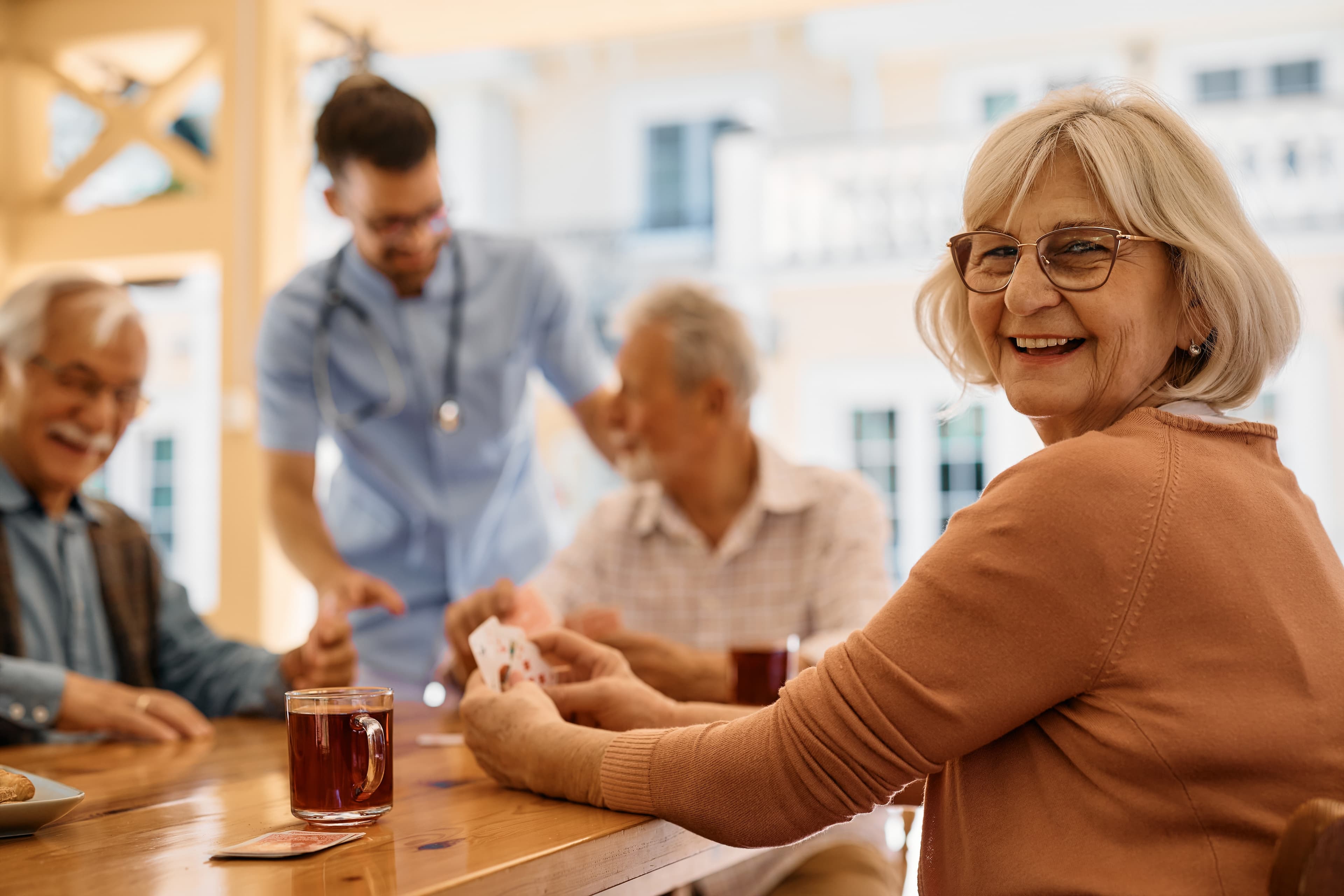 Happy mature woman enjoying playing card games
